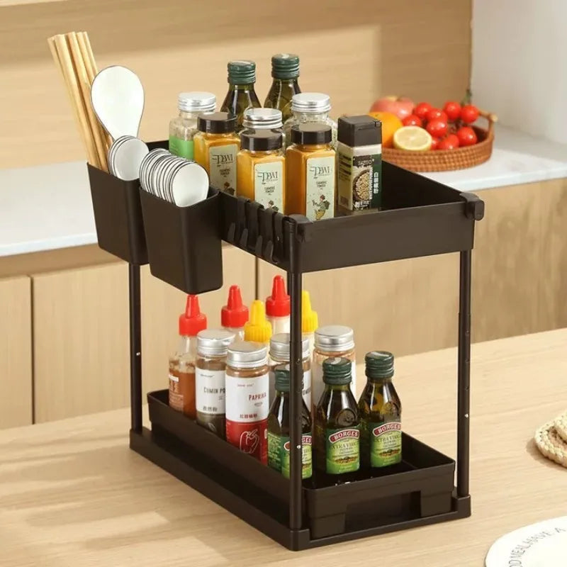 Black multi-tiered kitchen organizer with bottles and utensils on a wooden countertop.